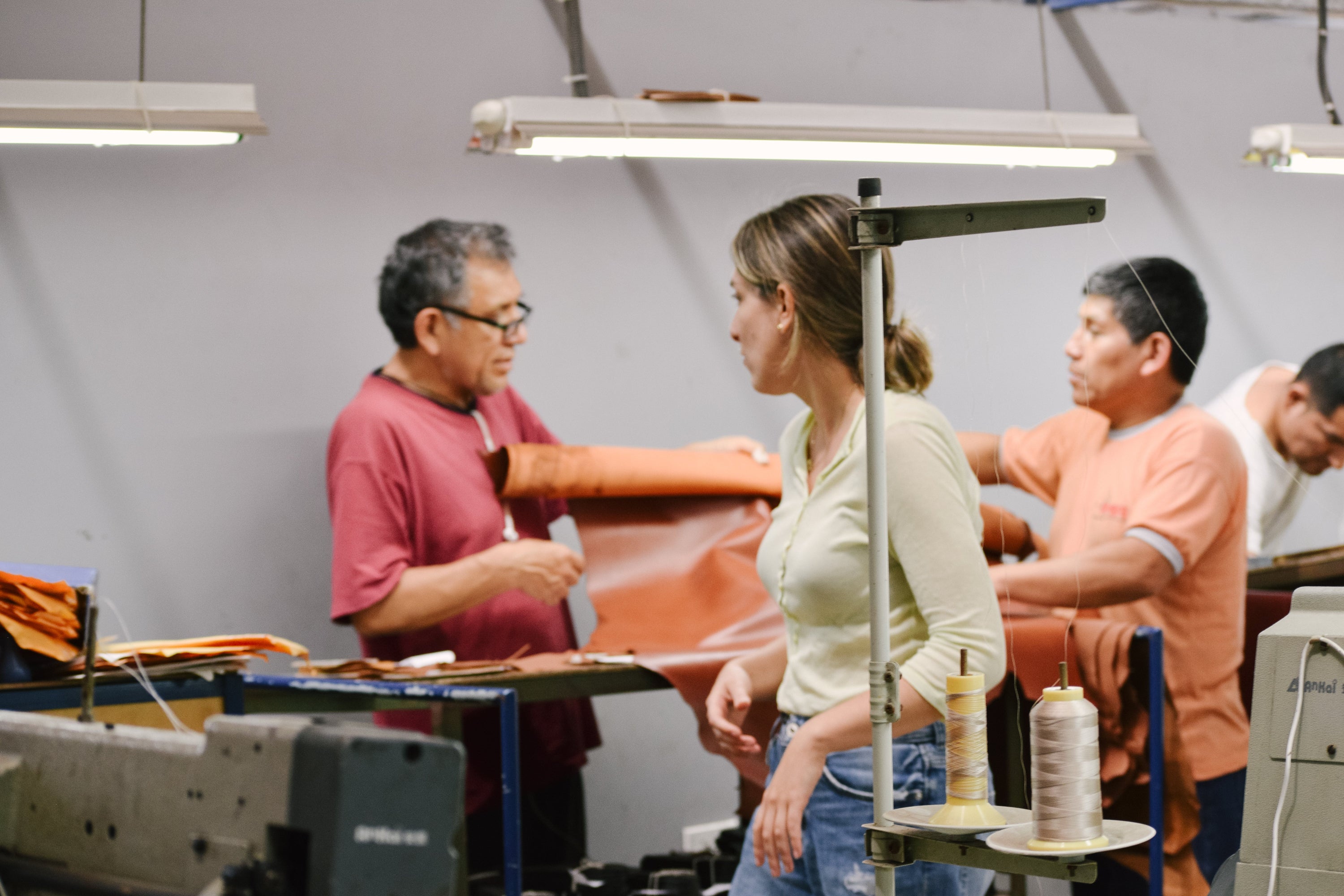 Workers operating sewing machines in a factory setting