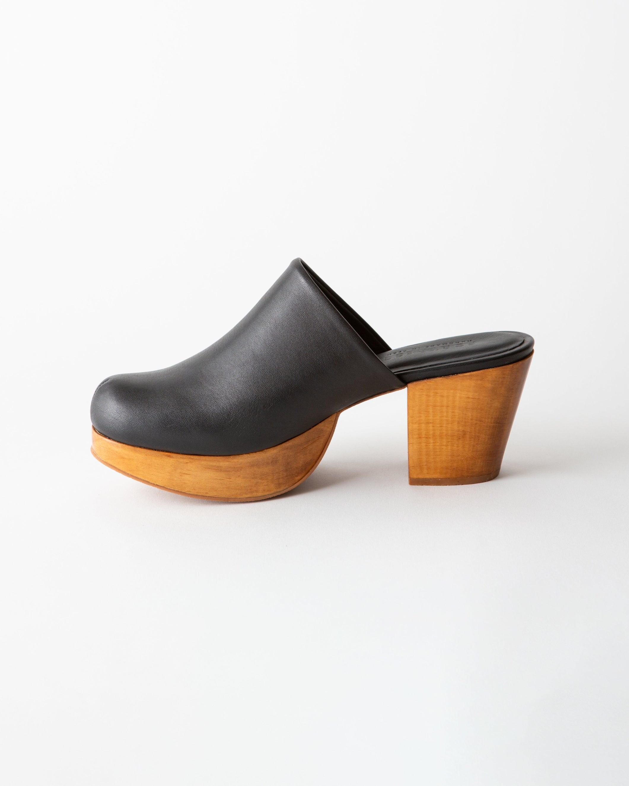 Black clog shoe with wooden sole on a white background