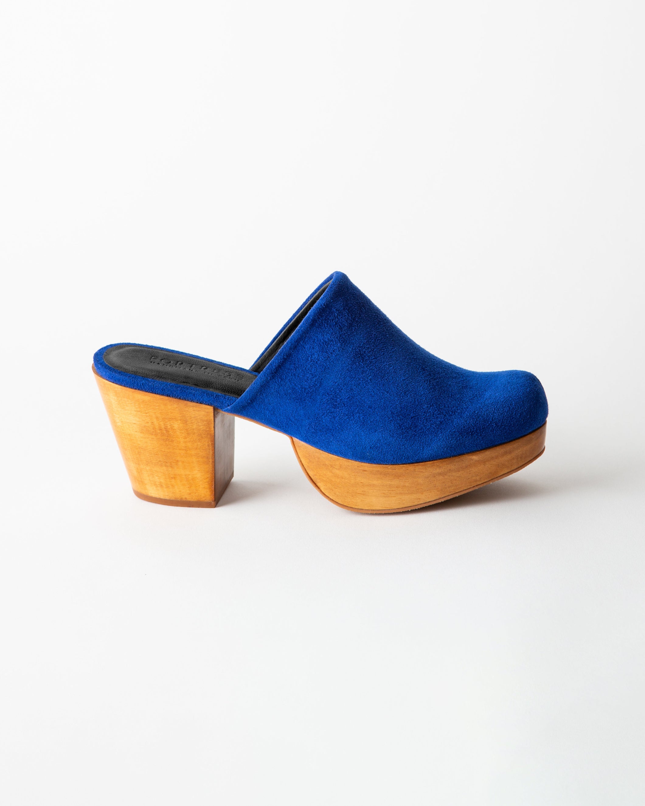 Blue suede clog shoe with wooden sole on a white background