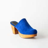 Blue suede clog shoe on a white background