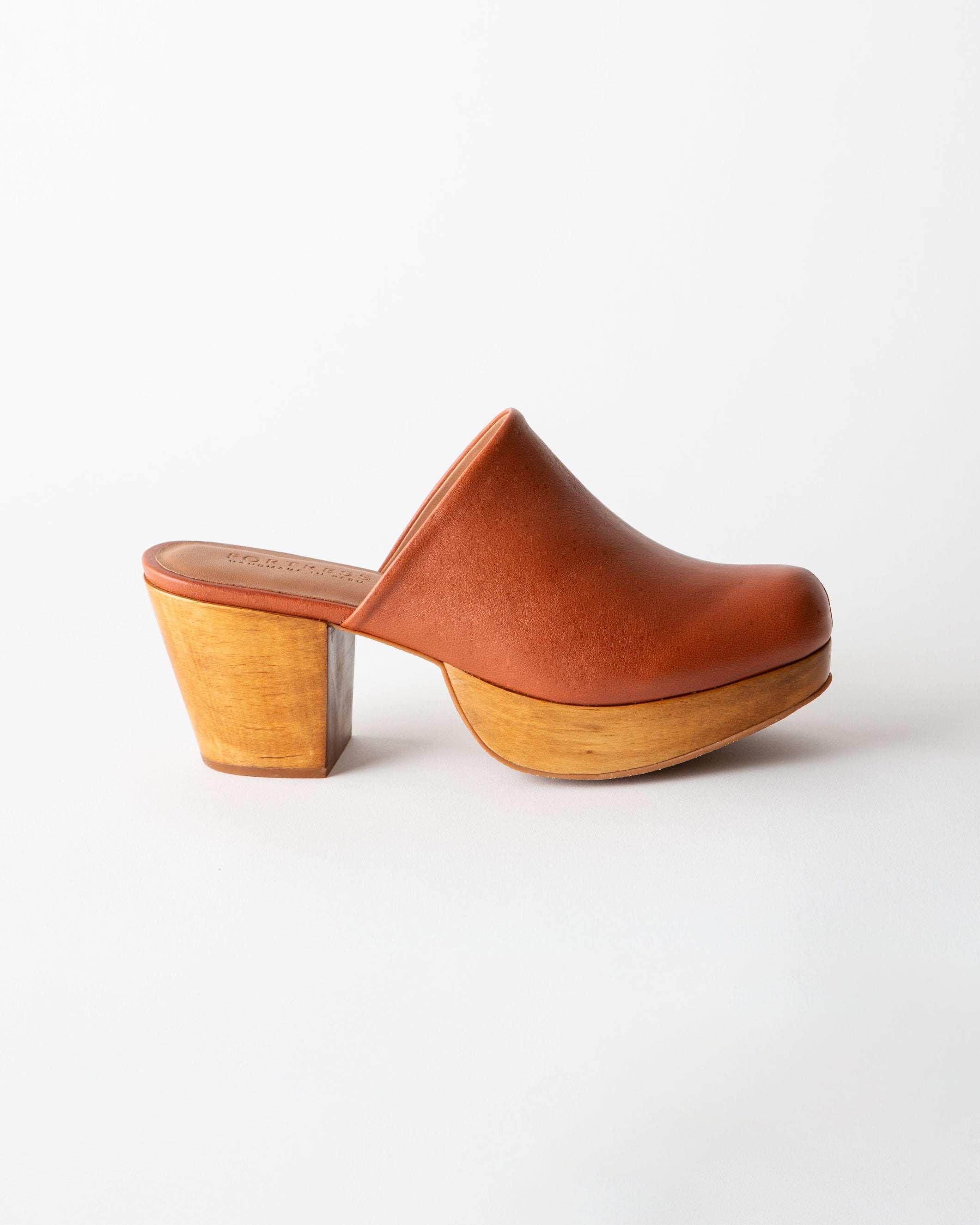 Brown leather clog shoe with wooden sole on a white background