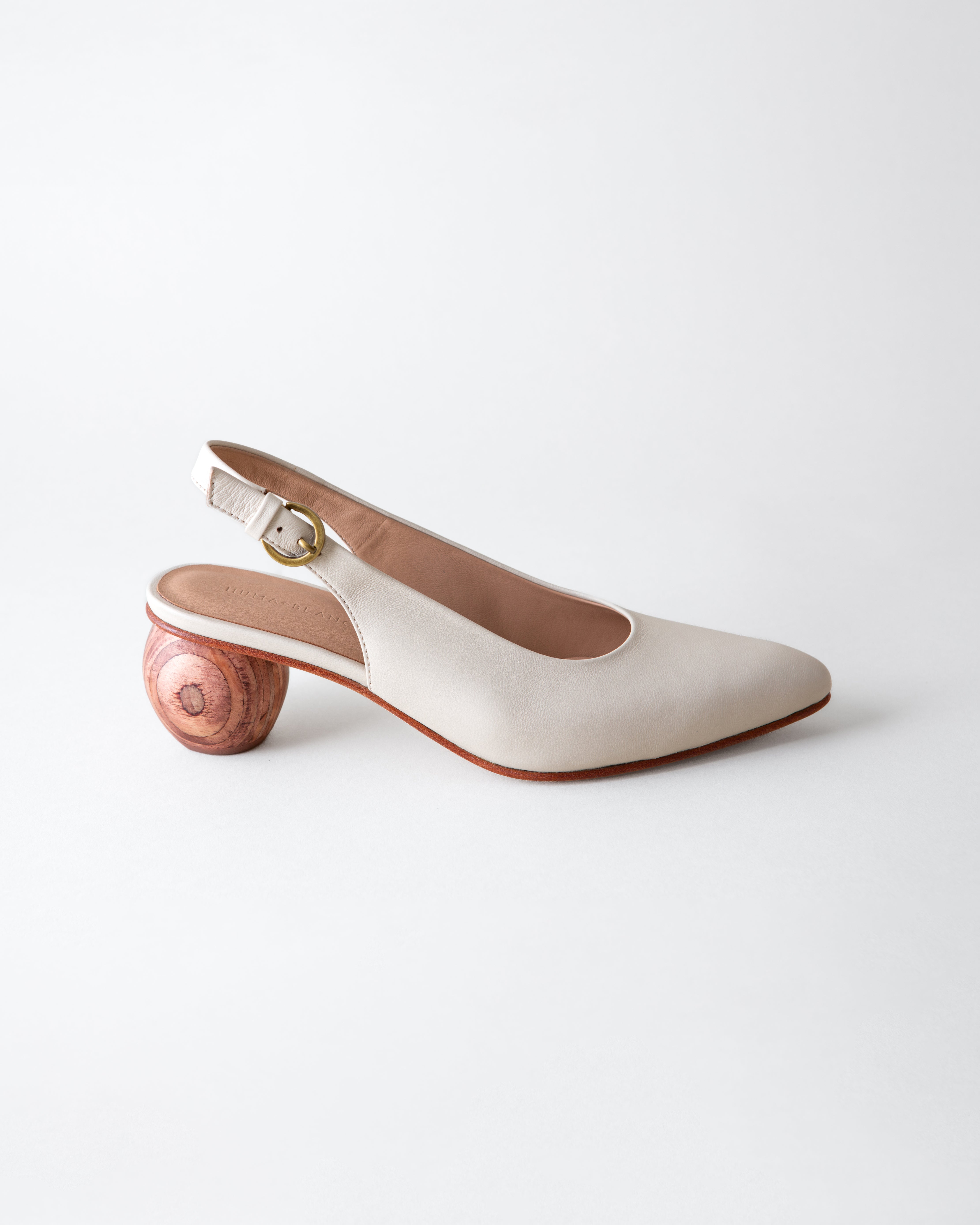 White shoe with wooden heel on a light gray background