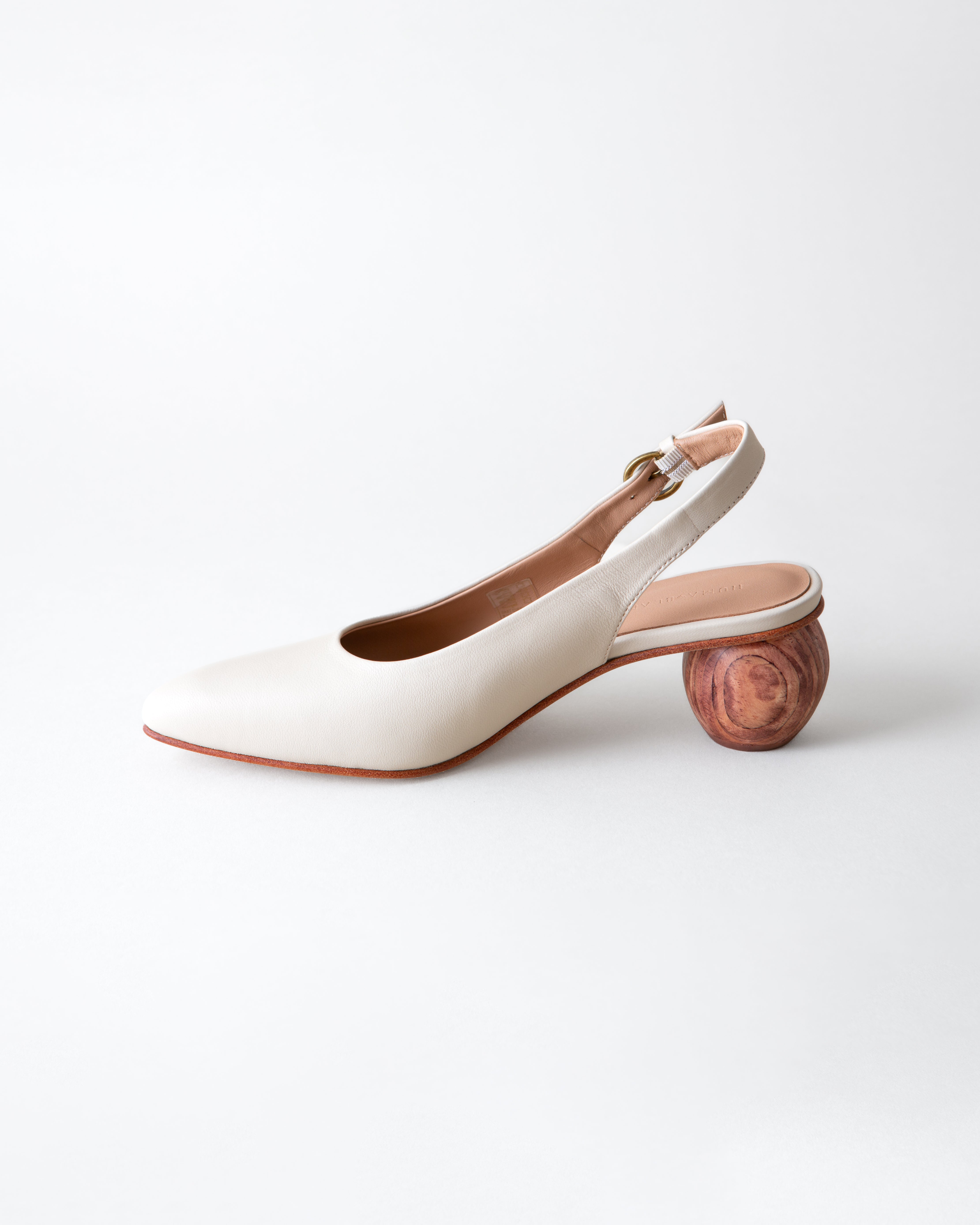 White shoe with wooden heel on a light gray background