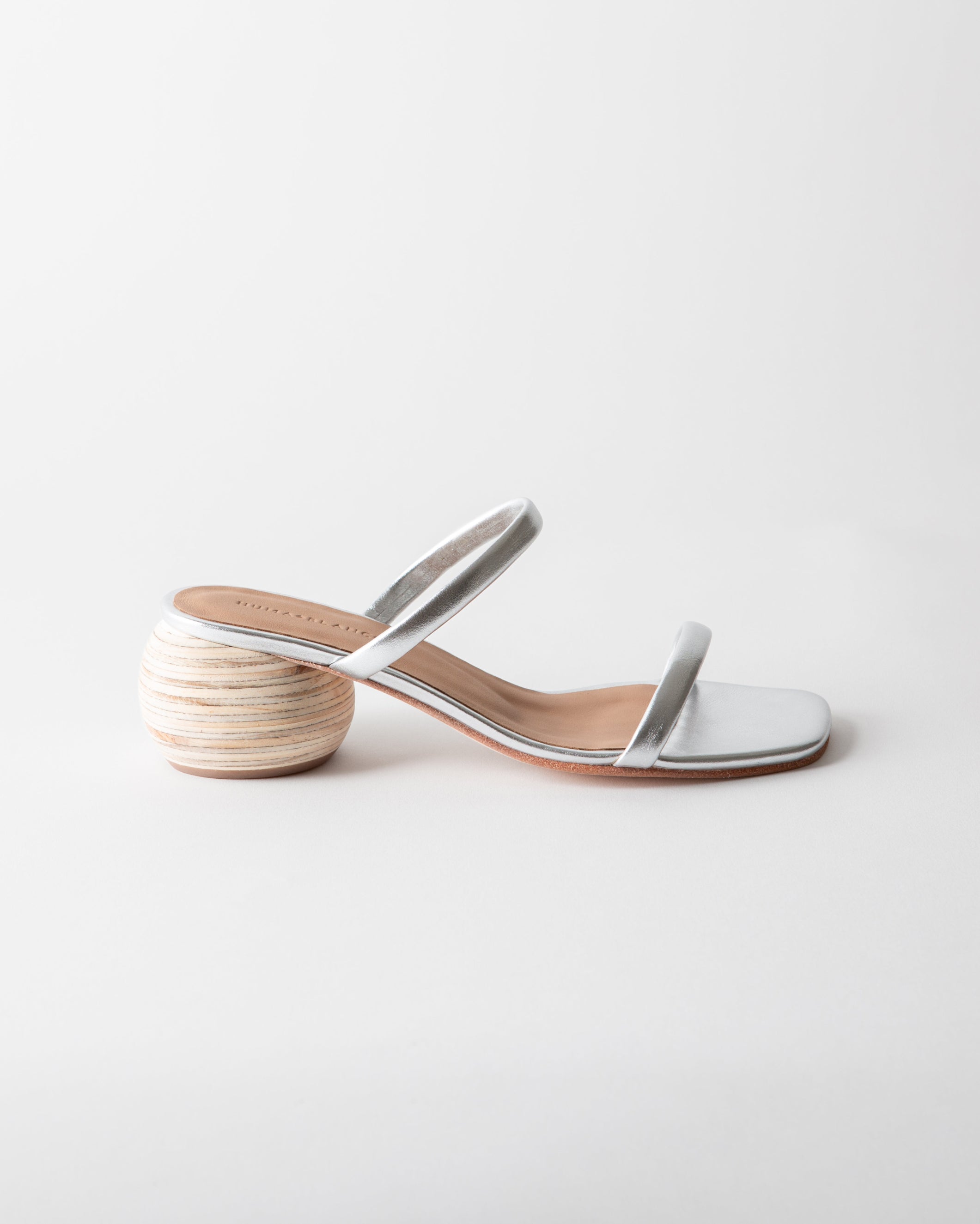 Silver sandal with wooden heel on a light gray background