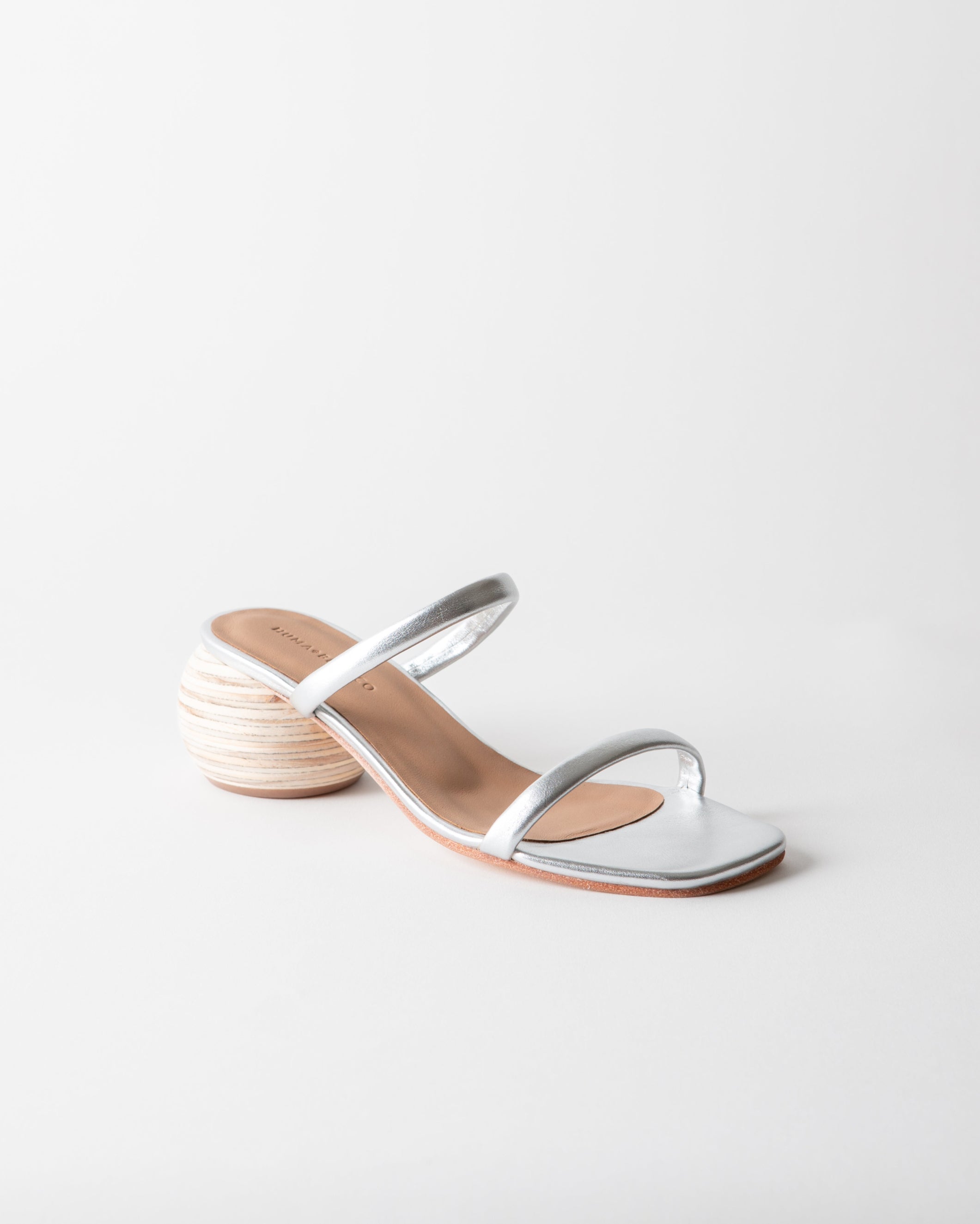 Silver sandal with a wooden heel on a light gray background