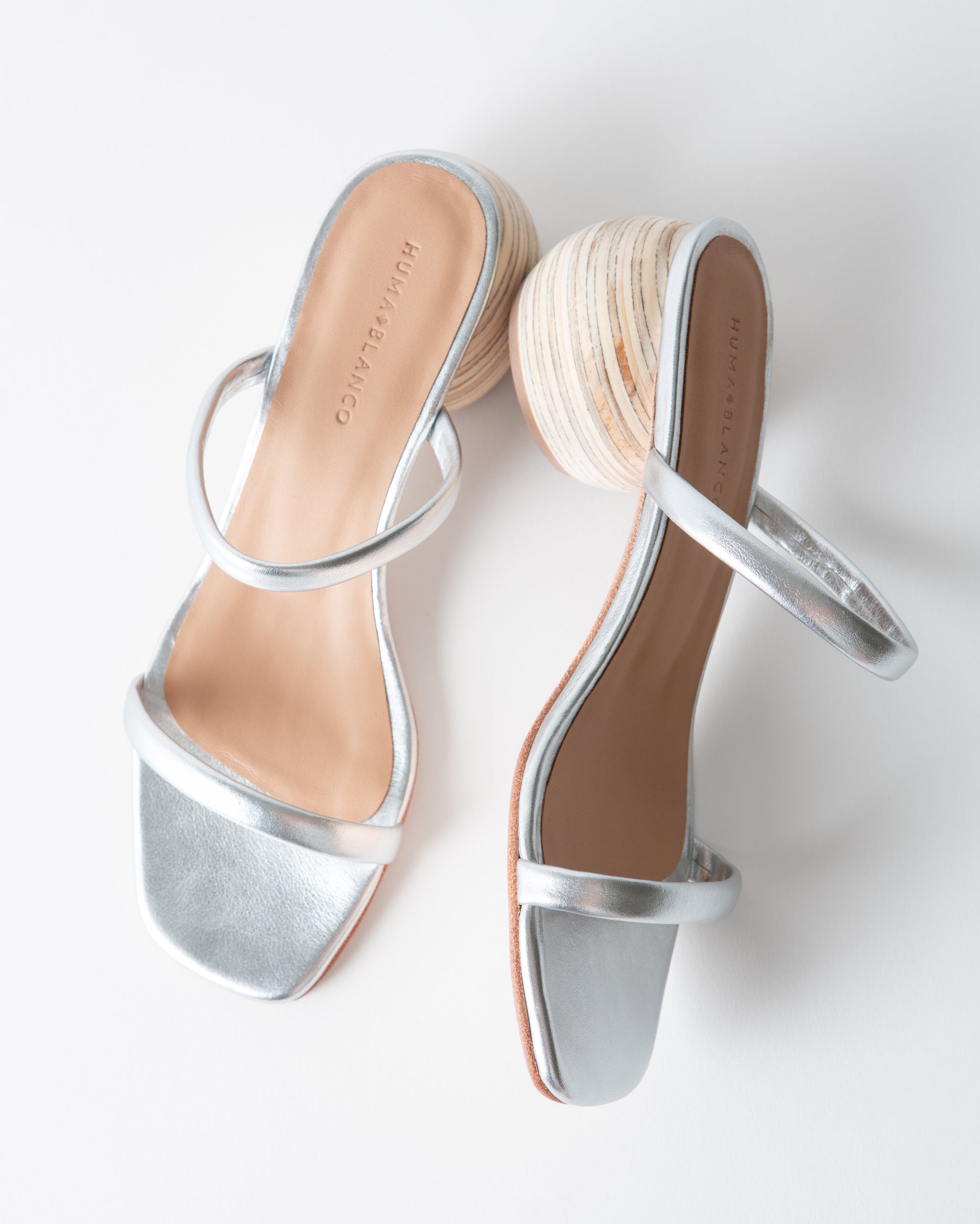 Silver high-heeled sandals on a white background