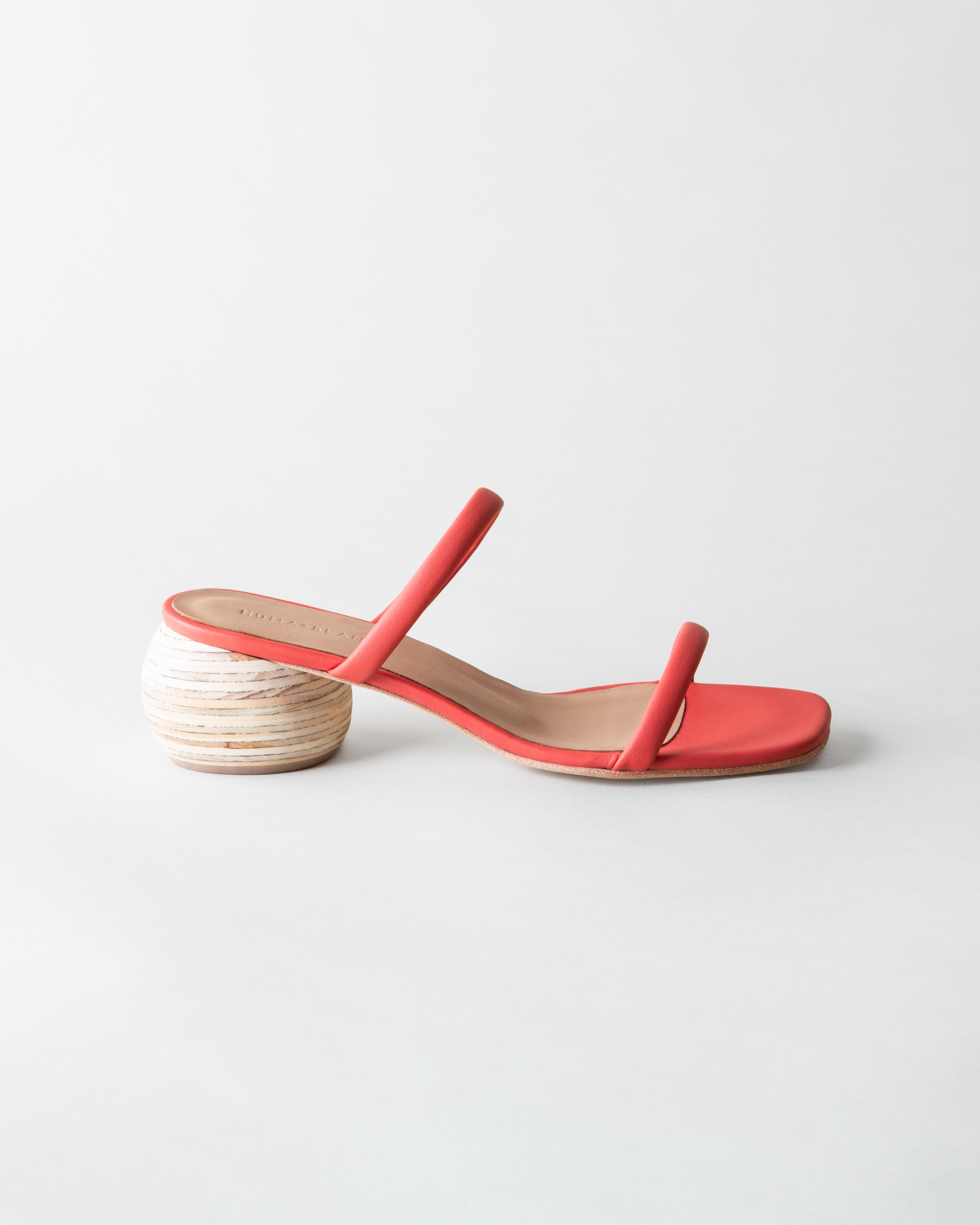 Red sandal with a wooden heel on a light gray background