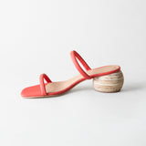 Coral sandal with wooden heel on a light gray background