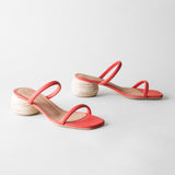 Coral sandals with wooden heels on a light gray background