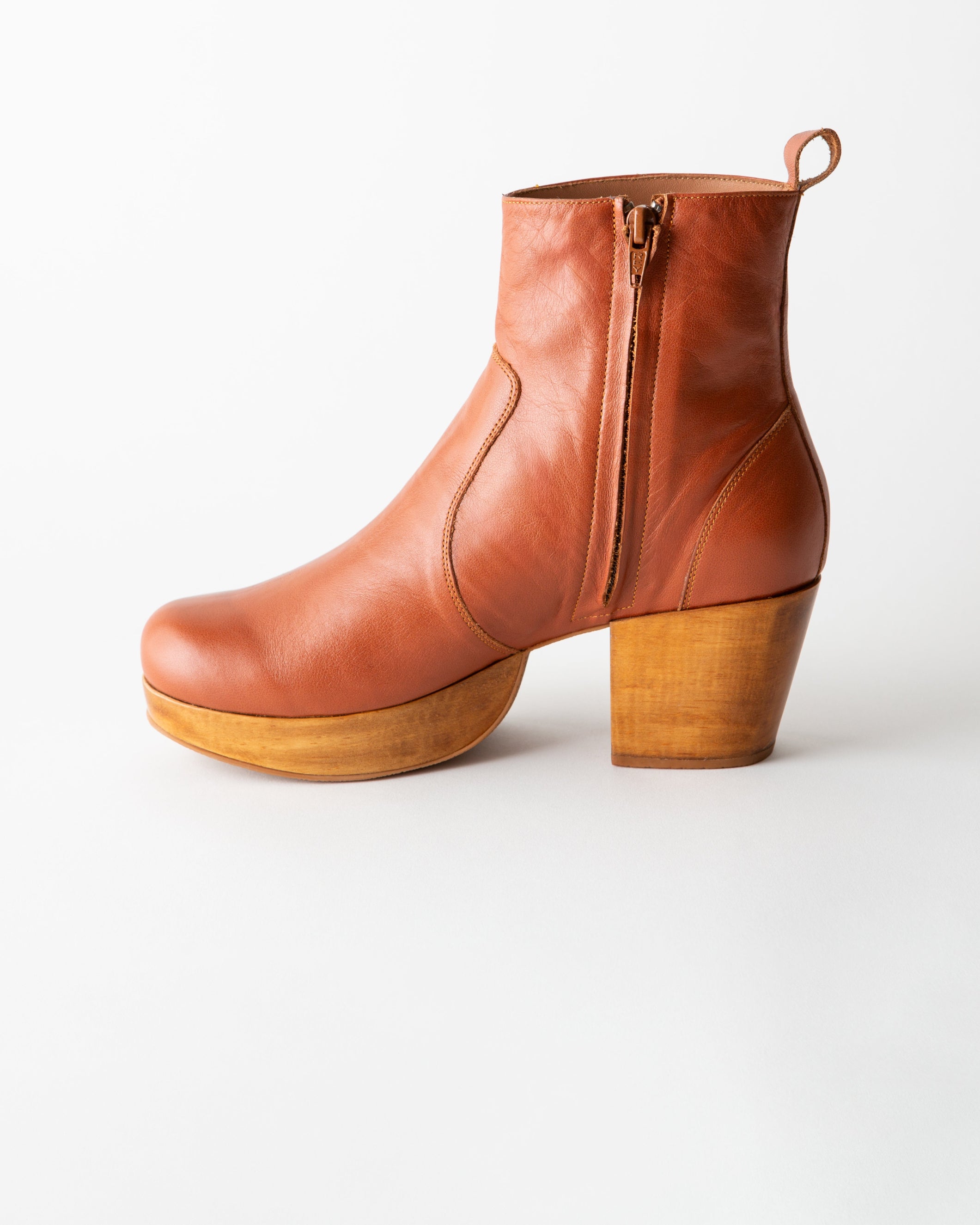 Brown leather boot with wooden sole on a white background