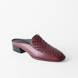 A single women's mule shoe in burgundy leather with a woven pattern on the upper and a low block heel, photographed on a clean white background.