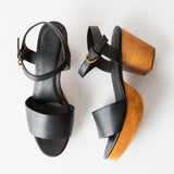 black leather clog sandals on a white background