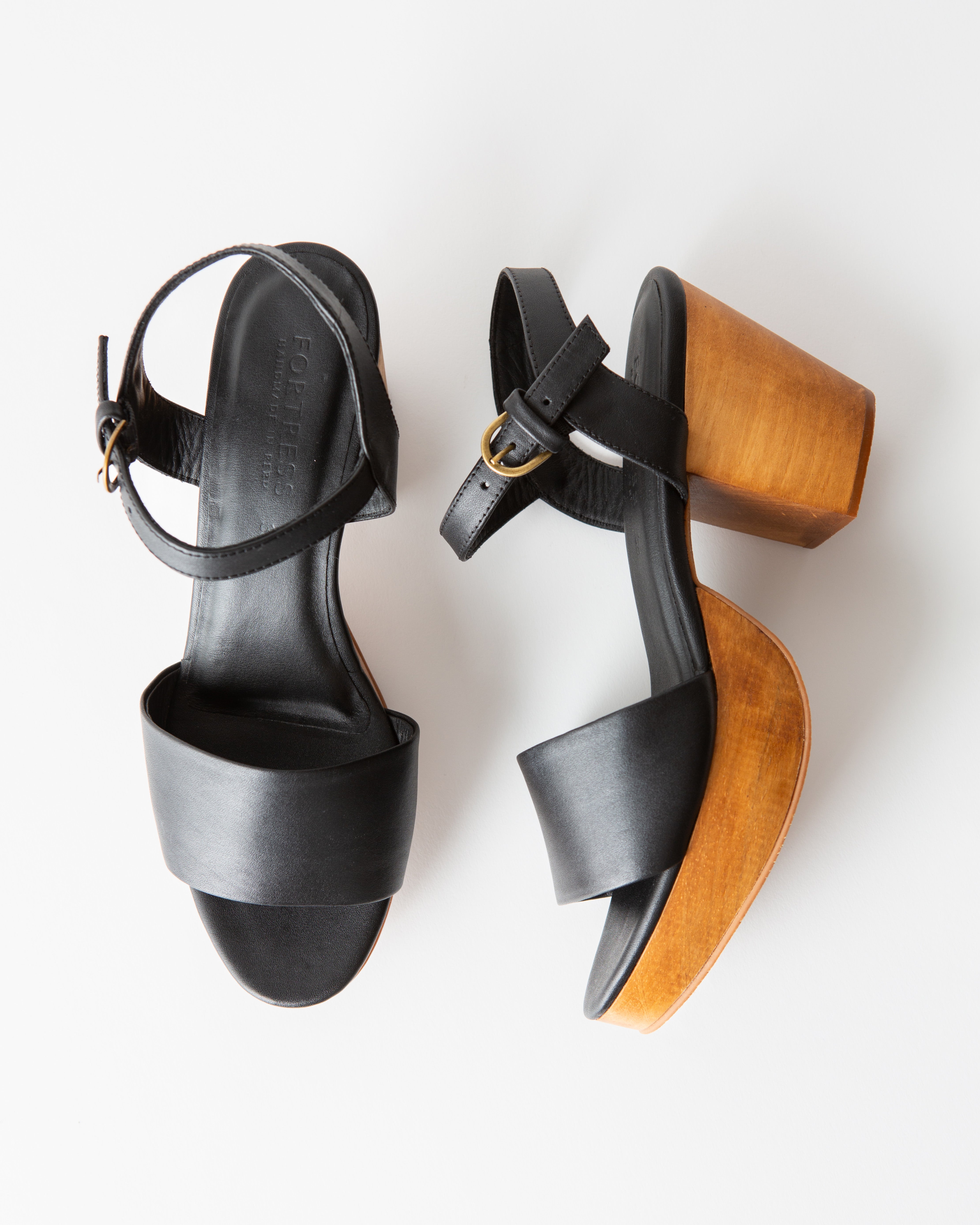 black leather clog sandals on a white background