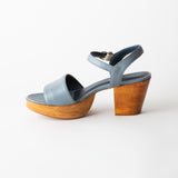Blue sandal with wooden platform sole on a white background