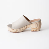 Off-white clog sandal with wooden platform on a white background