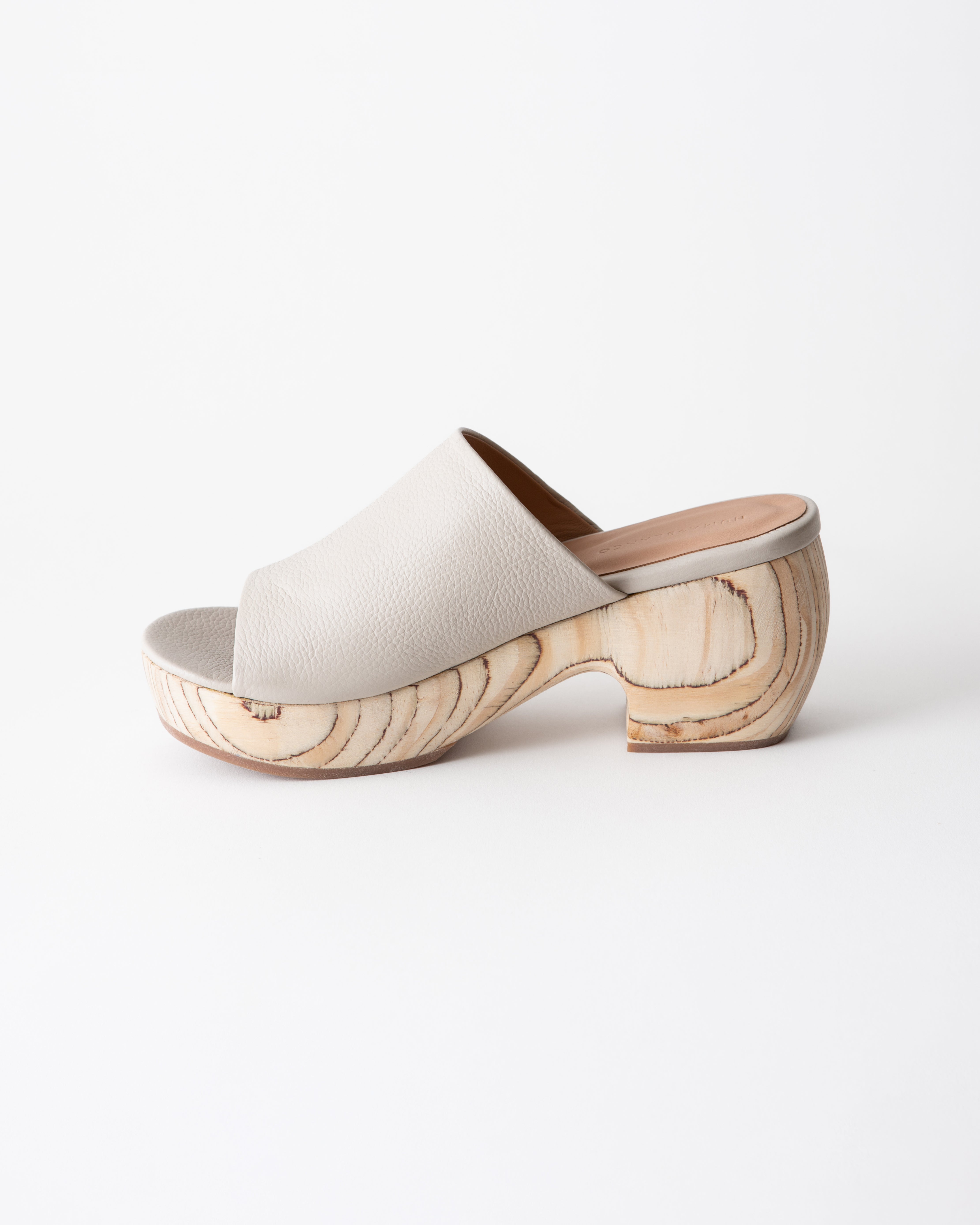 Off-white clog sandal with wooden platform on a white background
