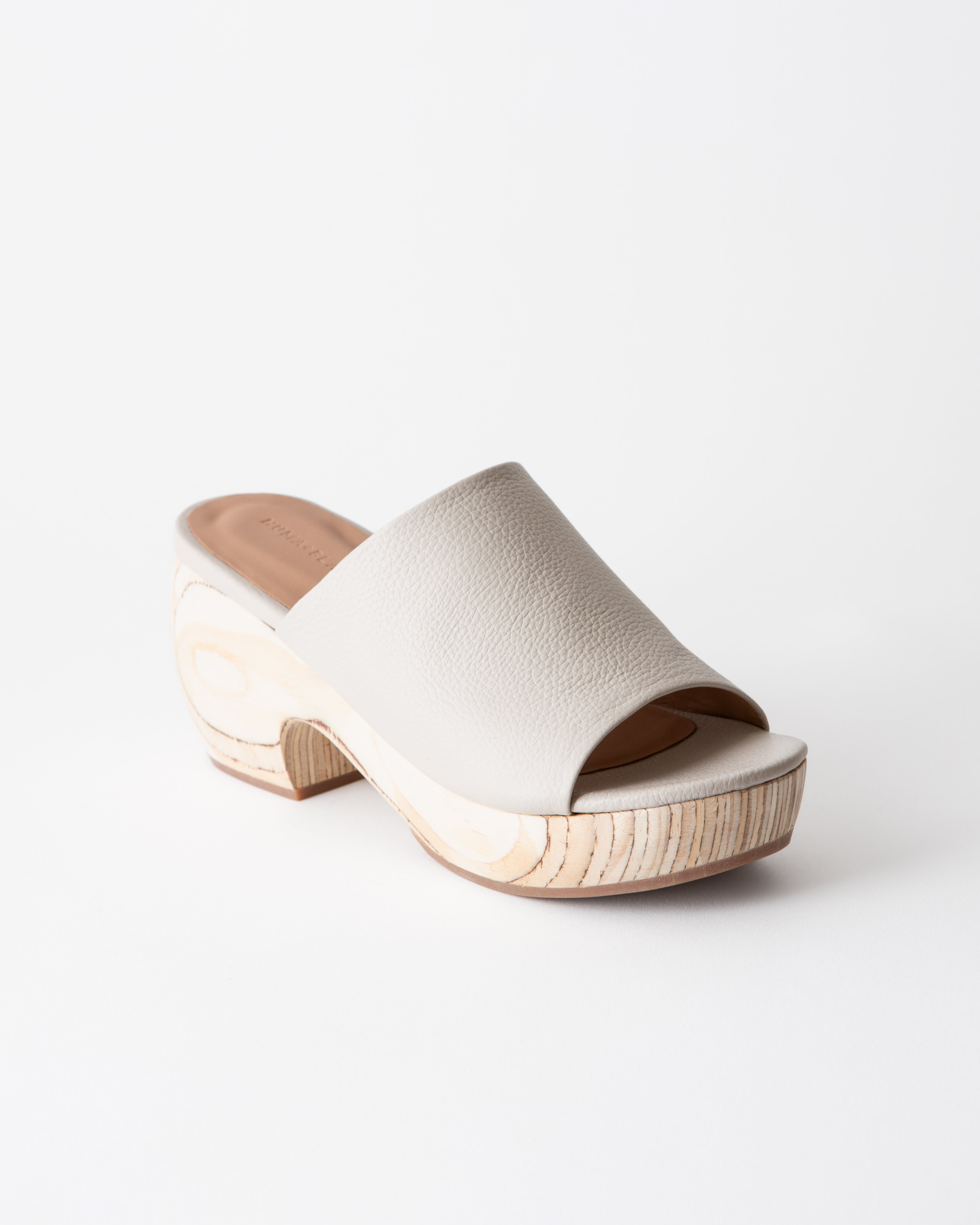 Off-white clog sandal with wooden platform on a white background