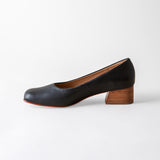 Black shoe with wooden heel on a white background
