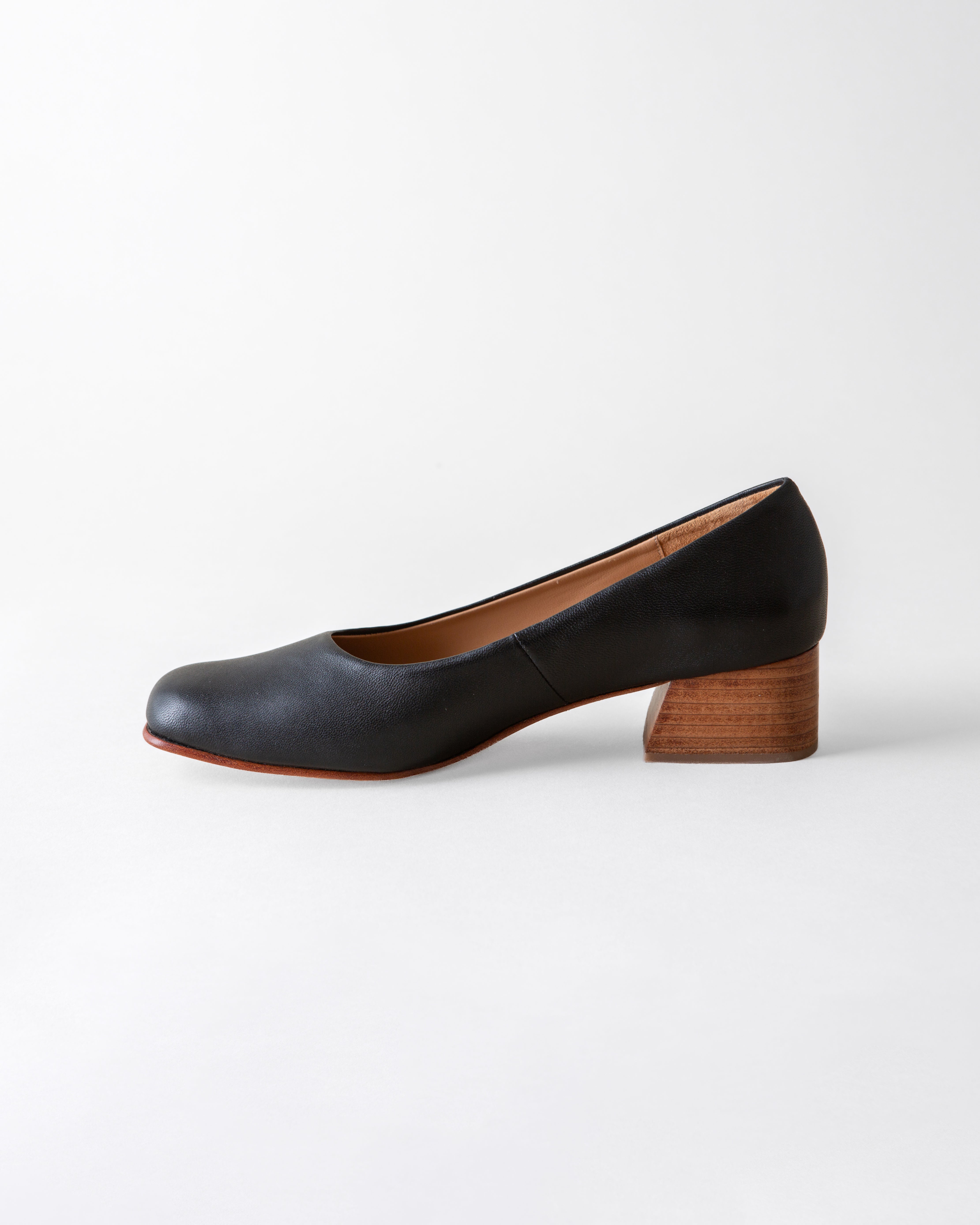 Black shoe with wooden heel on a white background