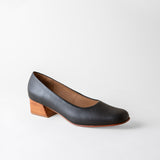 Black shoe with a wooden heel on a light gray background