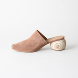 Beige suede slipper with wooden sole on a white background