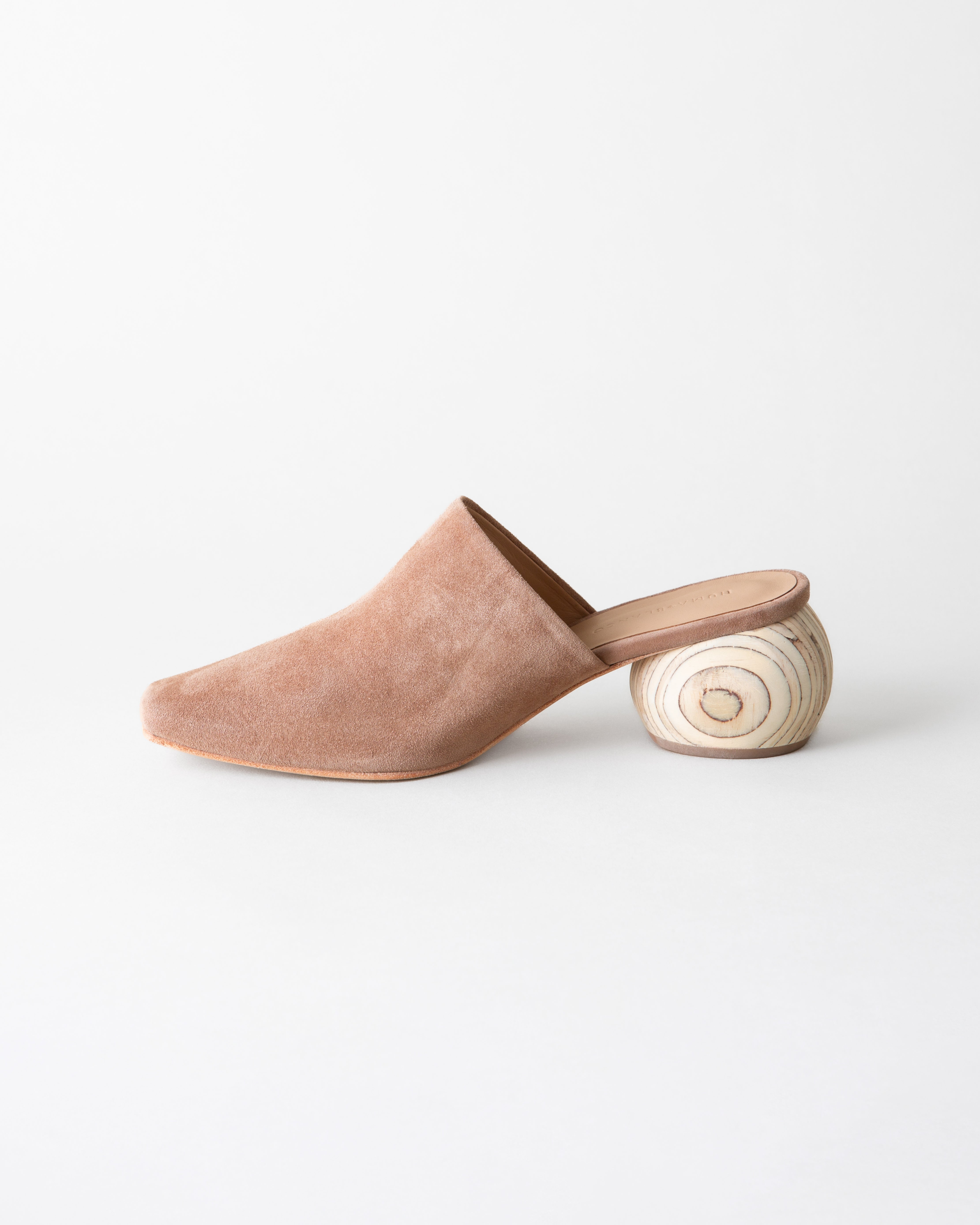 Beige suede slipper with wooden sole on a white background