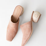 Pair of pink mules with wooden soles on a white background