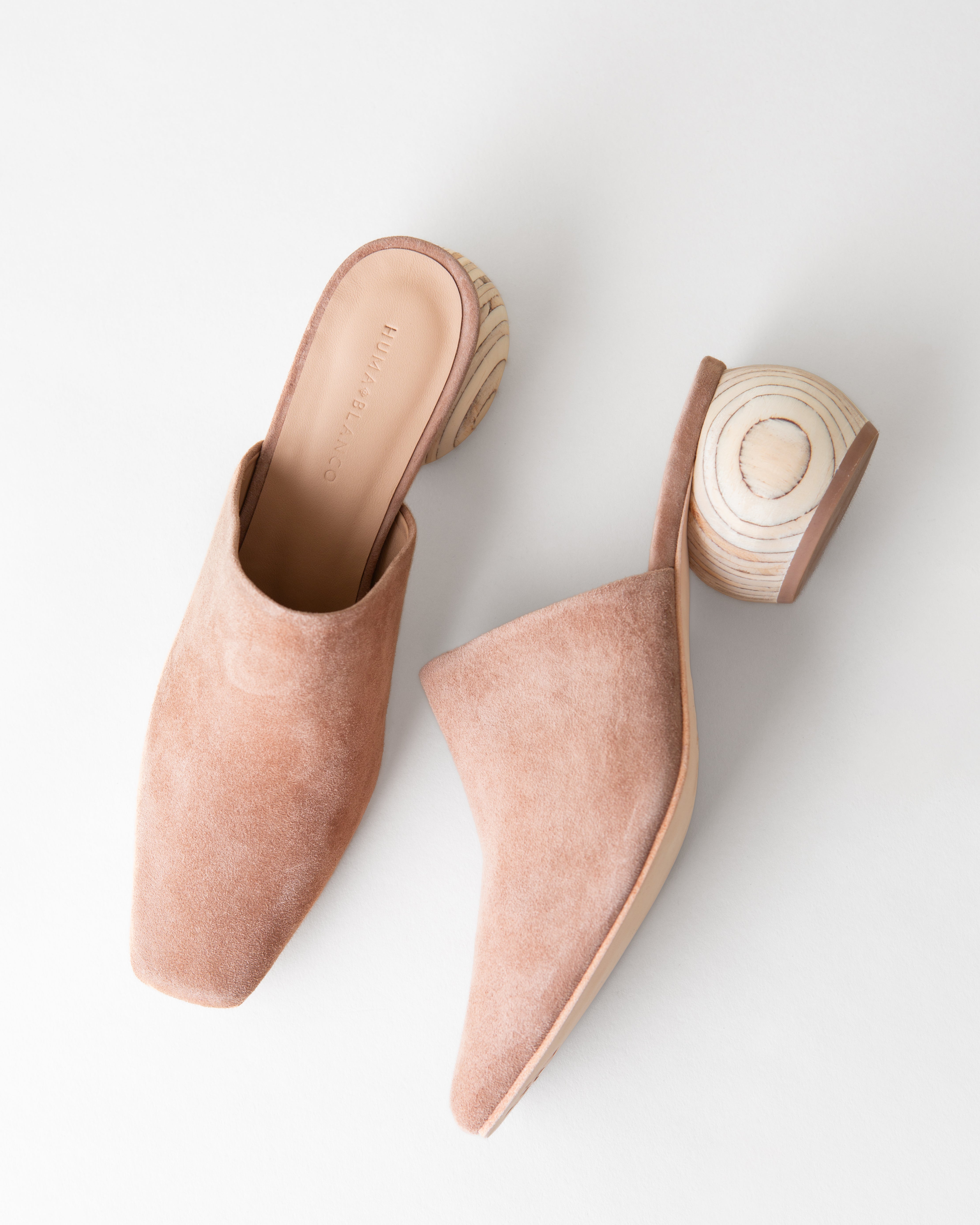 Pair of pink mules with wooden soles on a white background