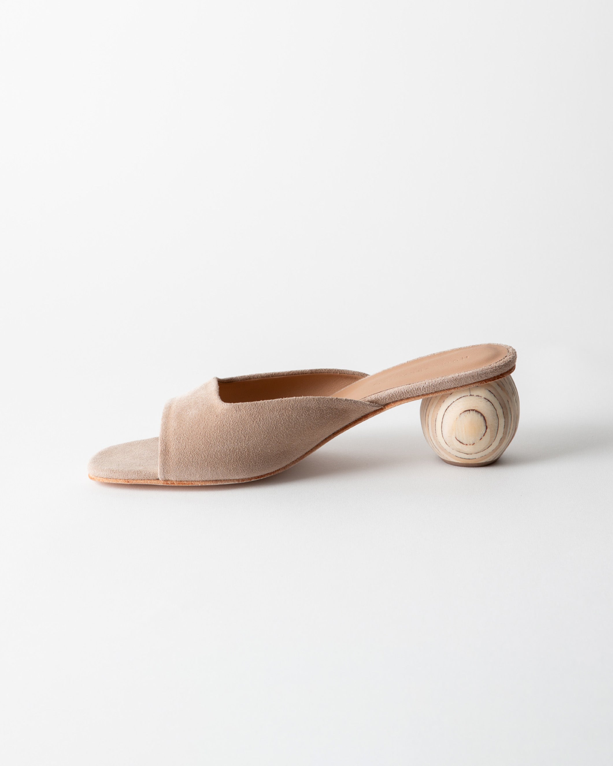 Beige open-toe sandal with a wooden heel on a light gray background