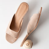 Beige open-toe sandal with a wooden heel on a light gray background