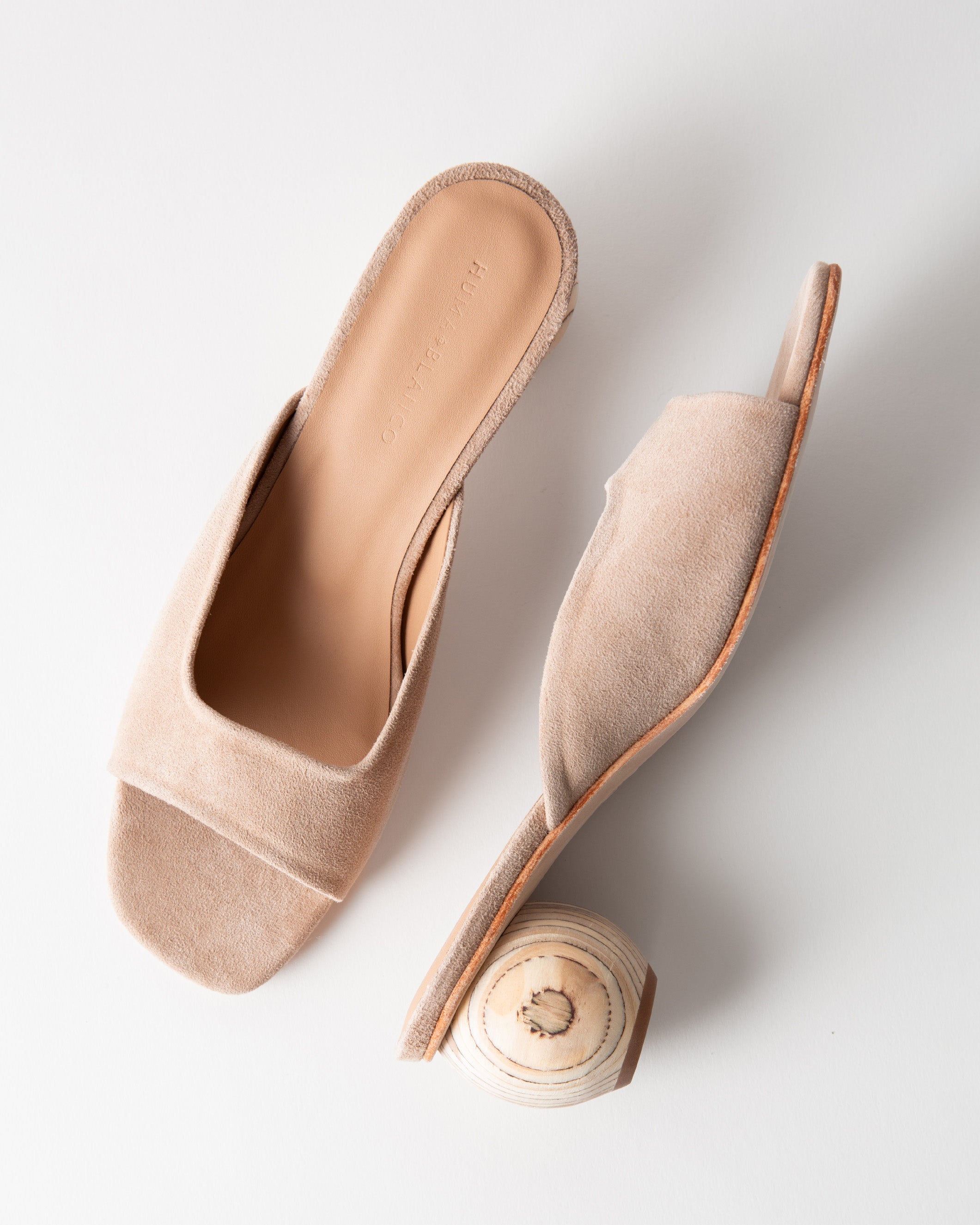 Beige open-toe sandal with a wooden heel on a light gray background