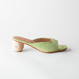 Green sandal with a wooden heel on a light gray background