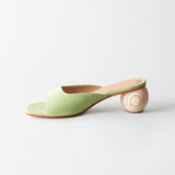 Green sandal with wooden heel on a light gray background