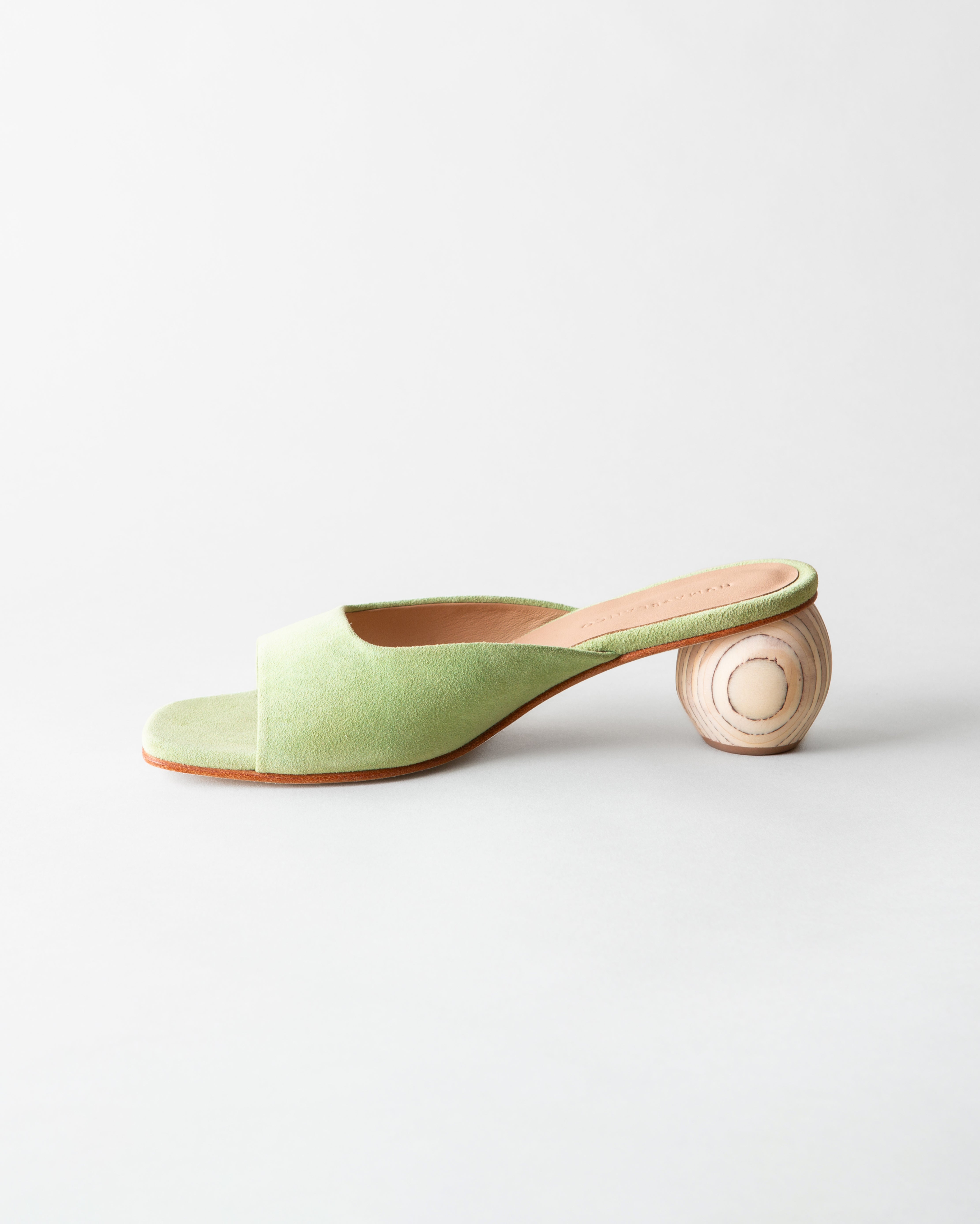 Green sandal with wooden heel on a light gray background