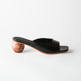 Black open-toe sandal with wooden heel on a white background