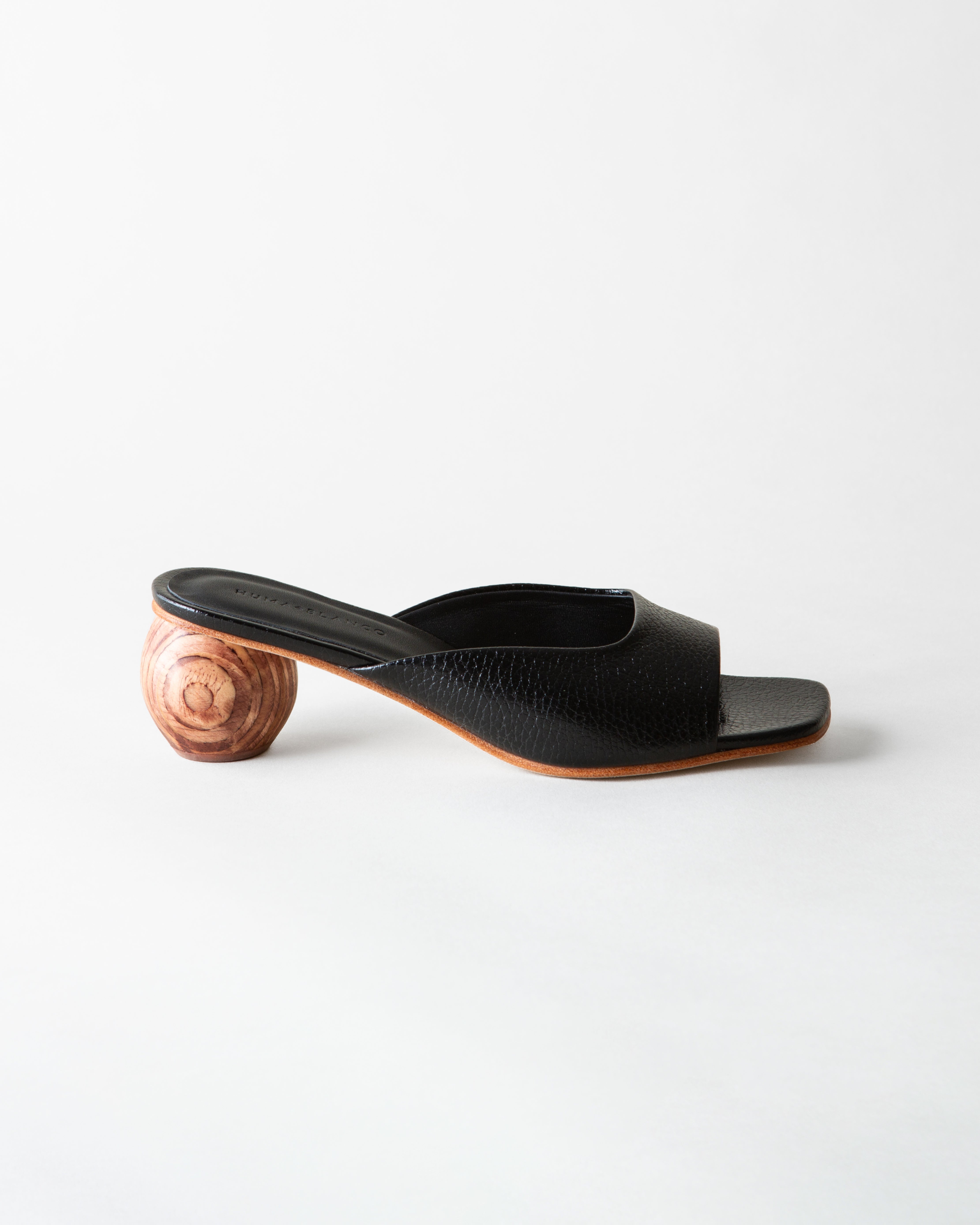 Black open-toe sandal with wooden heel on a white background