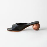 Black open-toe sandal with wooden heel on a white background