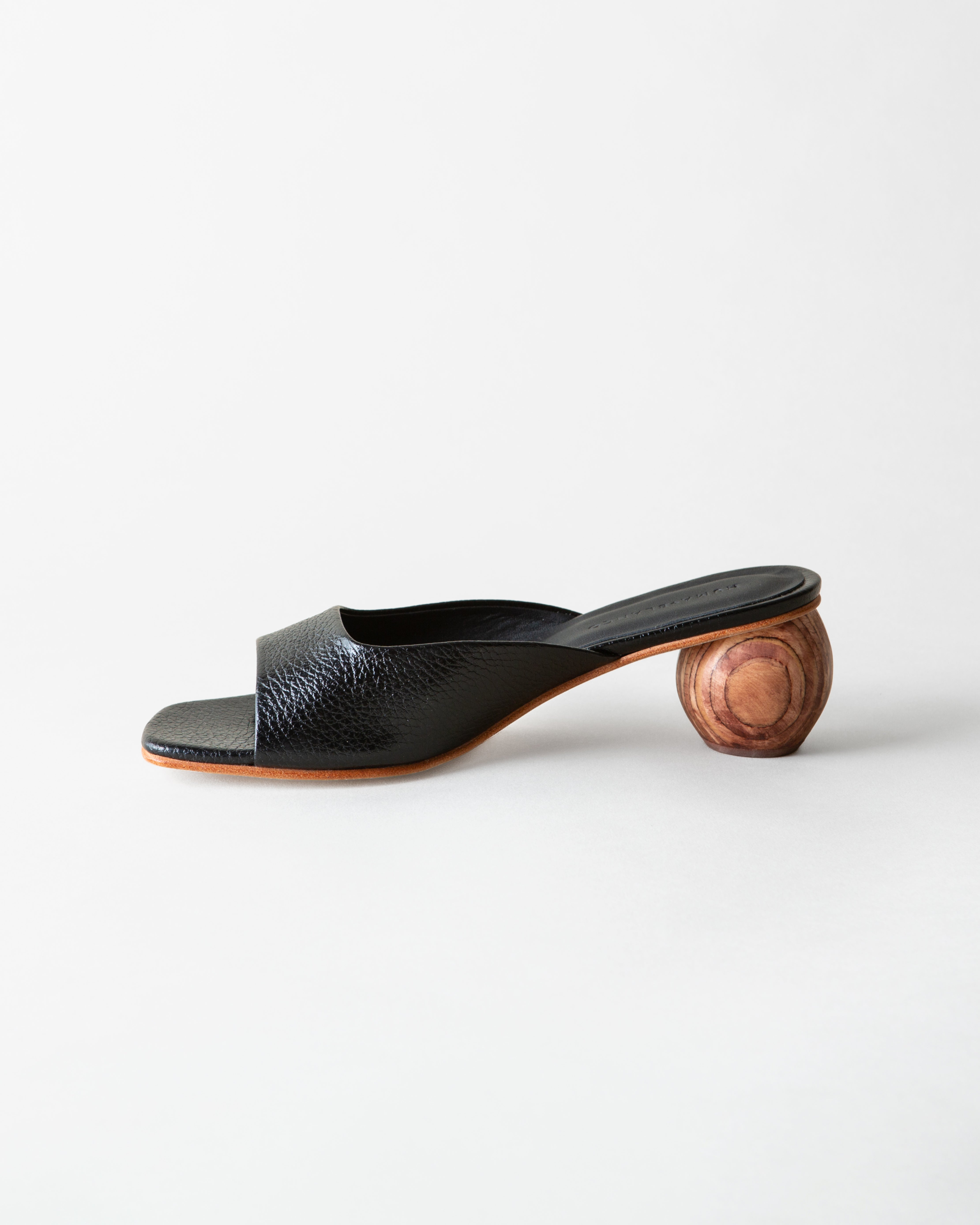 Black open-toe sandal with wooden heel on a white background
