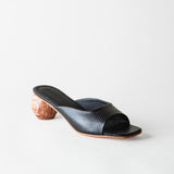 Black open-toe sandal with wooden heel on a white background