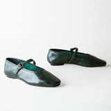 A pair of dark green snakeskin-textured Mary Jane flats with a small silver buckle, displayed on a clean white background.