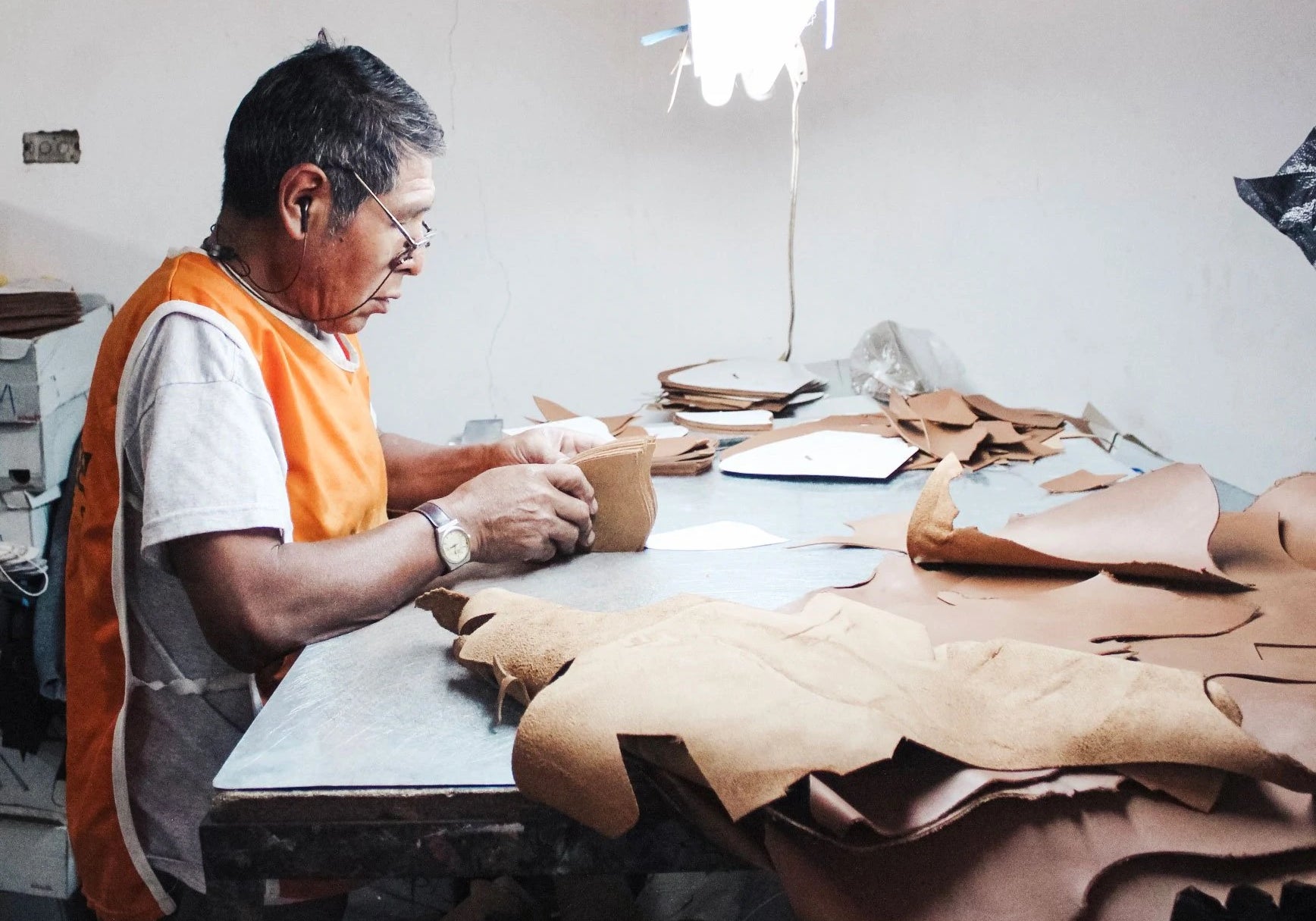 shoemaker cutting patterns into leather